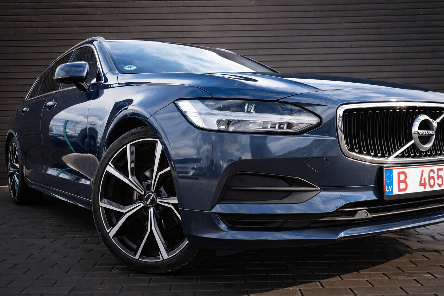 Polished blue Volvo on tiled pavement (1)